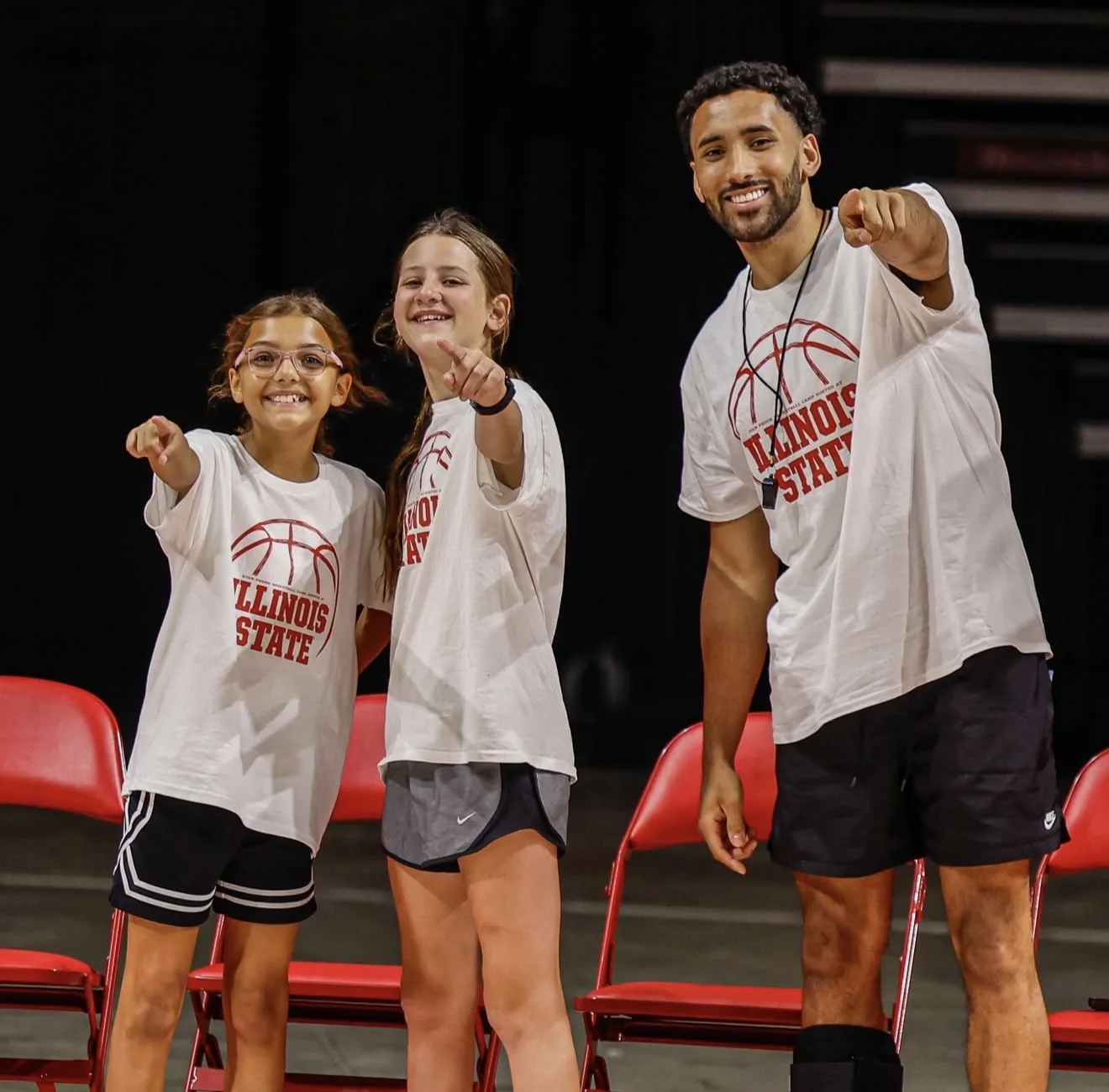 Dalton Banks smiling with two young basketball players at Illinois State