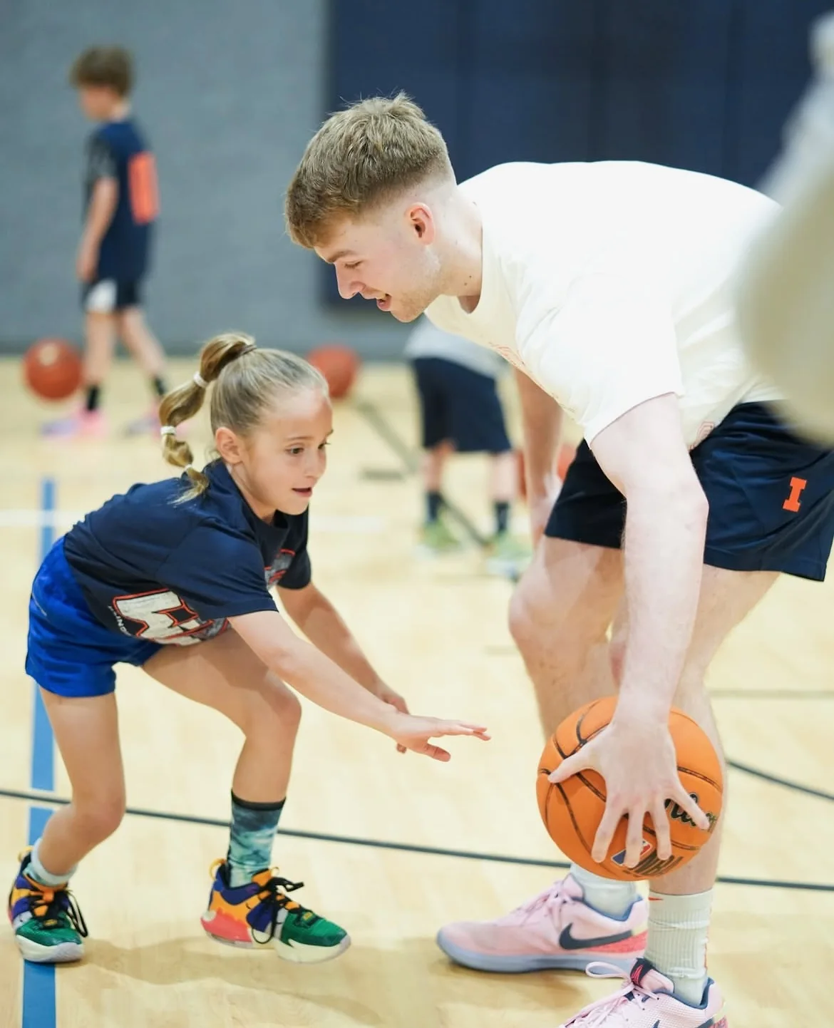 Marcus Domask showing a young player a basketball drill in the gym